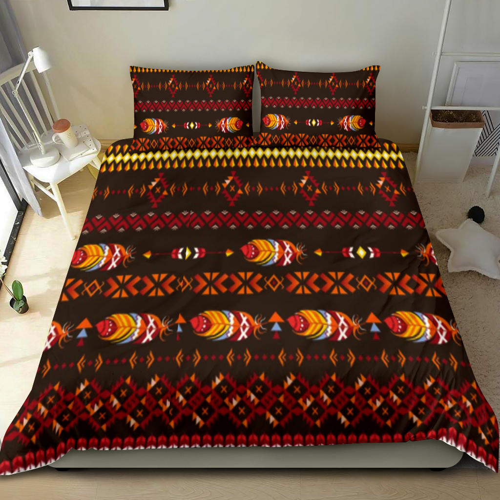 Native American feather motif bedding set on bed, dark fabric with red and multicolor design