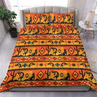 Bedding set on bed with orange, yellow, and teal tribal patterns and matching pillowcases