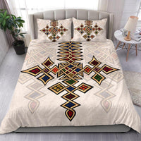Bedding set on bed with multicolor geometric tribal motif on light beige duvet and pillows