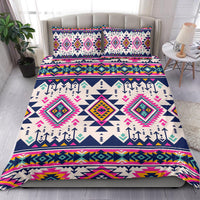 Bedding set on bed with two pillow shams; multicolor geometric diamond/arrow design