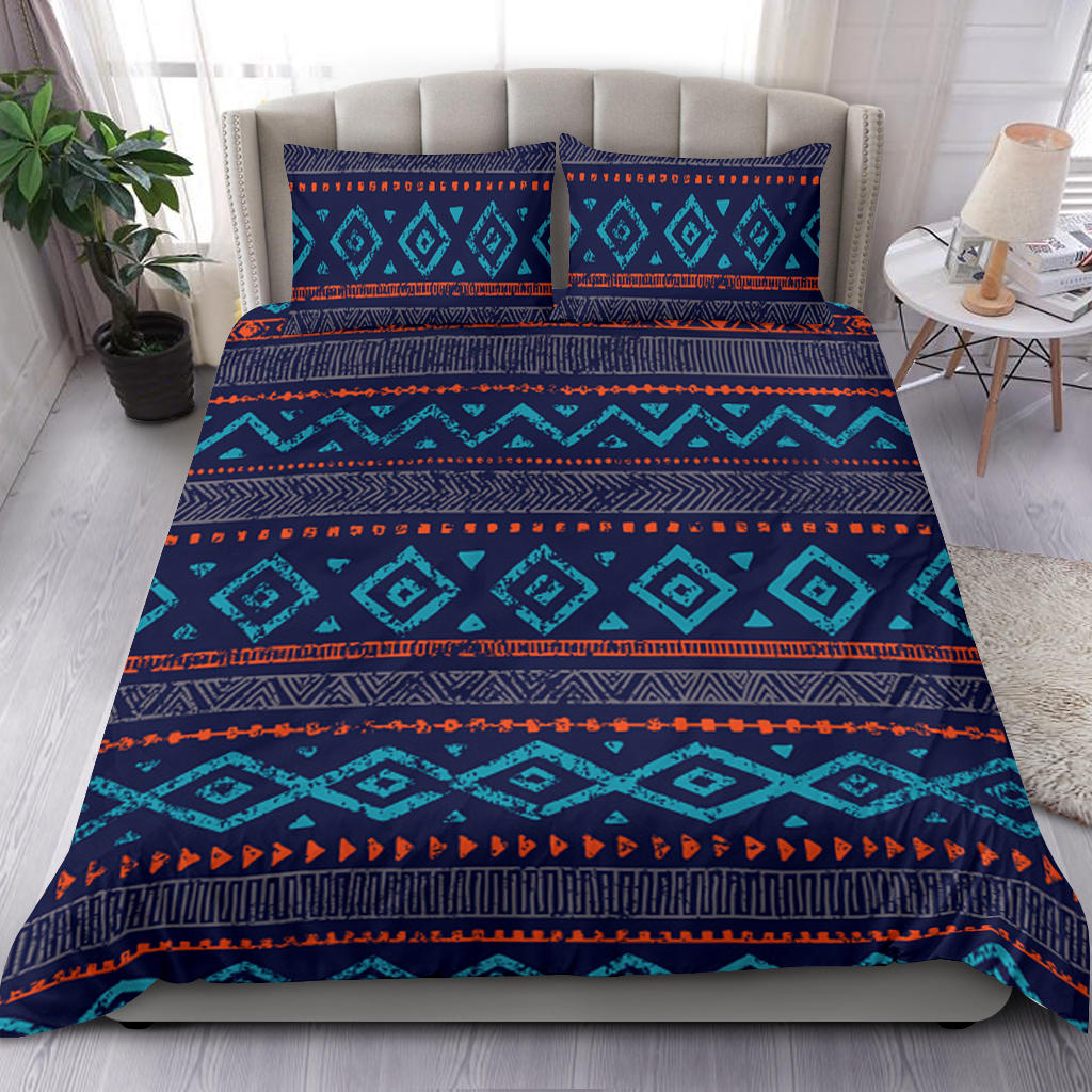 Native American style bedding set on bed: teal geometric blocks on navy with orange stripes