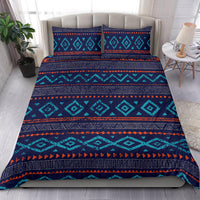 Native American style bedding set on bed: teal geometric blocks on navy with orange stripes