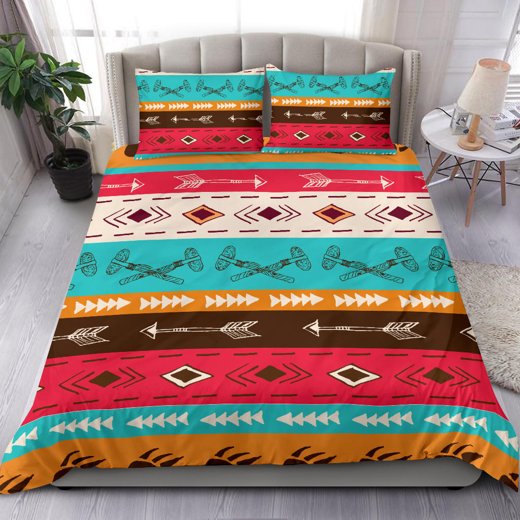 Colorful tribal bedding set on bed: teal, red, brown stripes, arrows, and diamond shapes