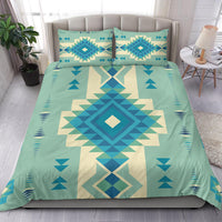 Full bedding set view: teal ground with blue and cream native-inspired geometric medallion