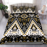 Tribal geometric bedding set on bed, black white and gold with tree and arrow details