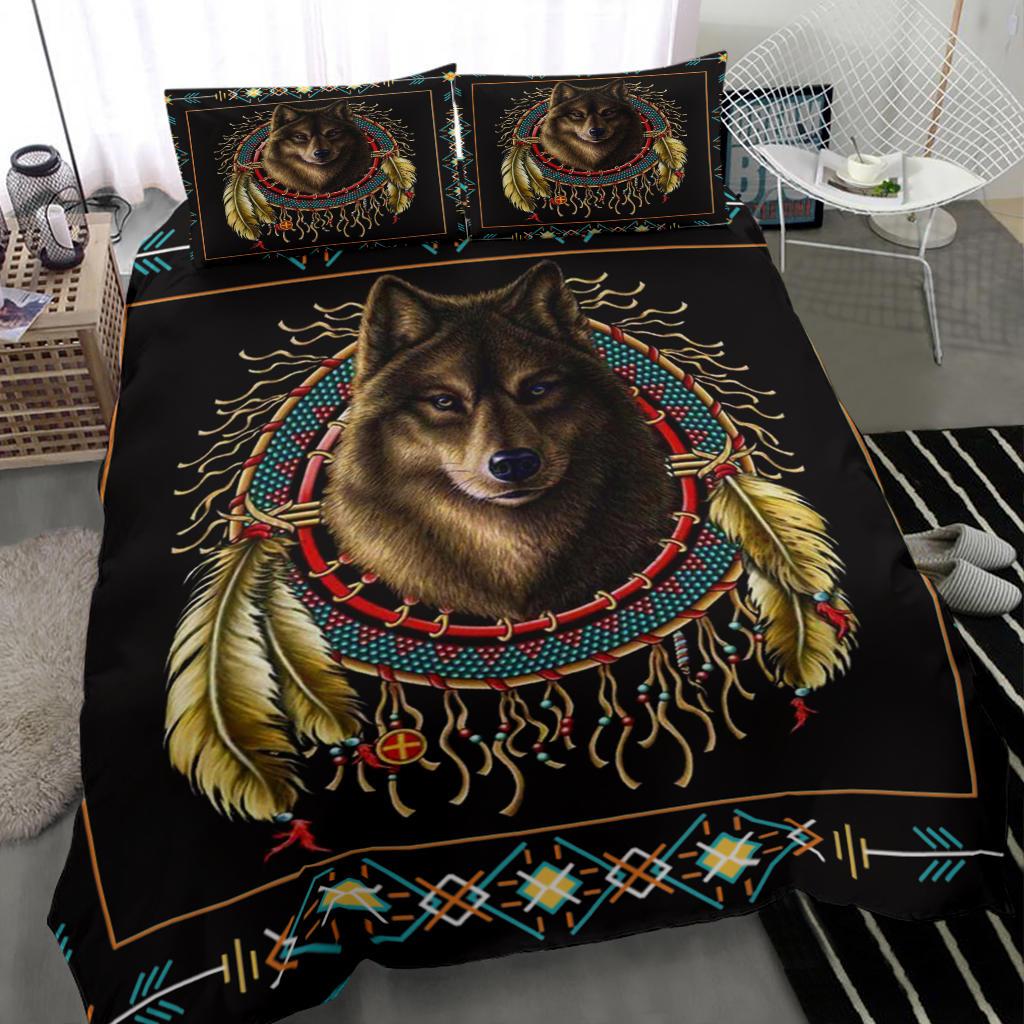 Close view of black comforter with brown wolf portrait, dreamcatcher feathers, and geometric border