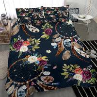 Close view of navy dreamcatcher bedding: roses, leaves, and feather details