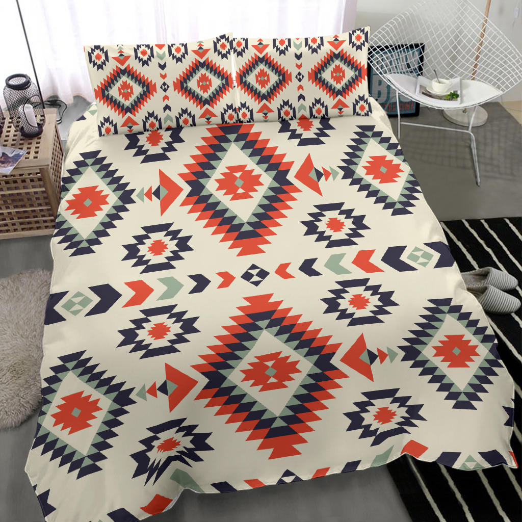 Geometric bedding set: cream quilt with red, navy, and green repeating diamond motifs