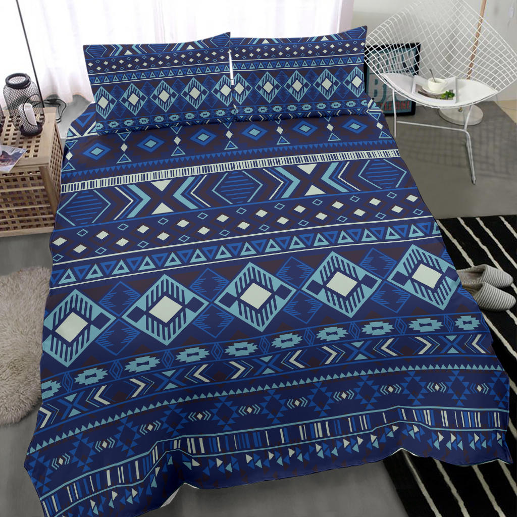Navy patterned comforter with teal, cream, and blue diamond shapes and zigzag trim