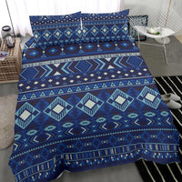 Navy patterned comforter with teal, cream, and blue diamond shapes and zigzag trim