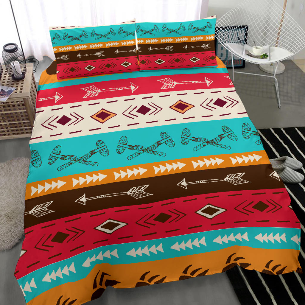 Close view of colorful Native-style duvet with teal, red, brown arrows, diamonds, and orange trim