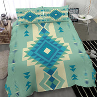 Teal bedding set close view with repeating geometric icons, triangles and diamond pattern