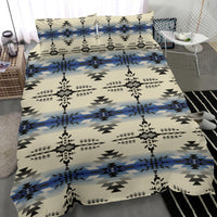 Close view of cream bedding with black and blue geometric pattern; fitted bed look