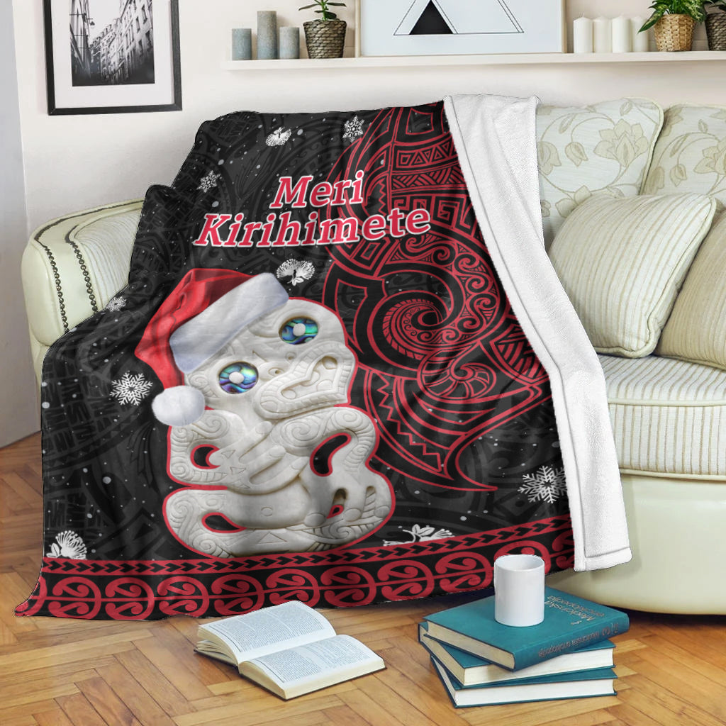 Red/black Christmas blanket with Hei Tiki face and “Meri Kirihimete”