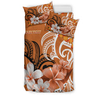 Stacked view of orange duvet with two pillowcases featuring large flowers and white swirls