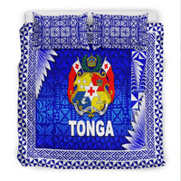 Close-up of blue Tonga bedding set with coat of arms crest, TONGA text, decorative border