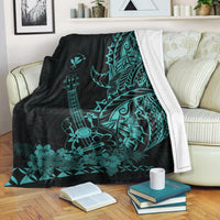 Black and turquoise Hawaiian blanket with ukulele and floral tiki motifs, draped on sofa