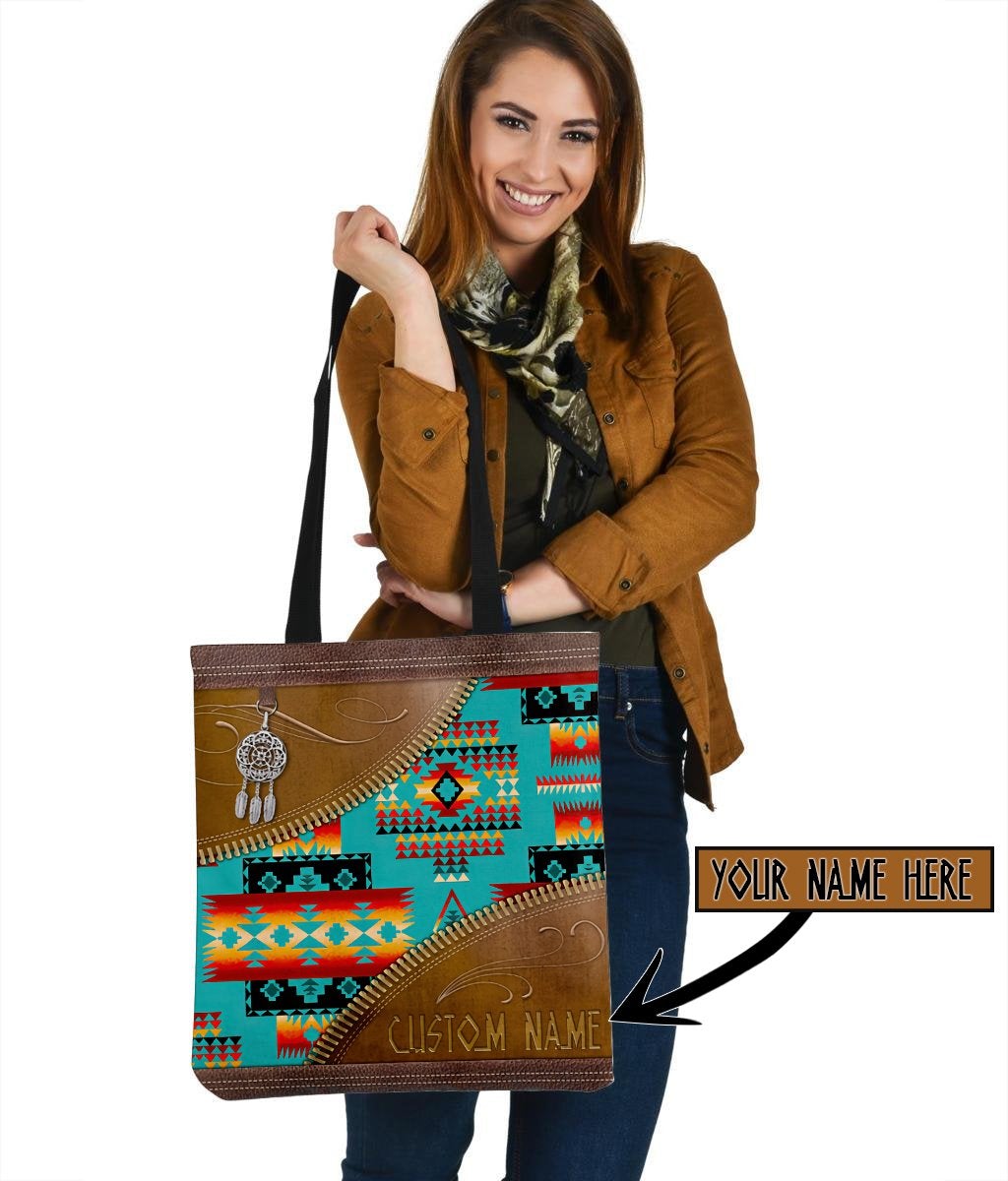 Front view: multicolor native canvas tote with brown trim, black handles, “Your Name Here”