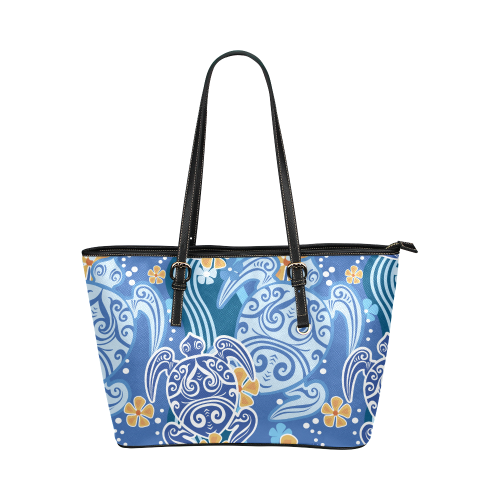 Blue patterned leather tote bag with black handles and zip-top opening