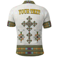 White polo shirt back shows YOUR TEXT and cross and floral Ethiopian motifs