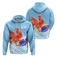 Blue pullover hoodie with tapa pattern, red rooster holding rugby ball; RA logo on chest.