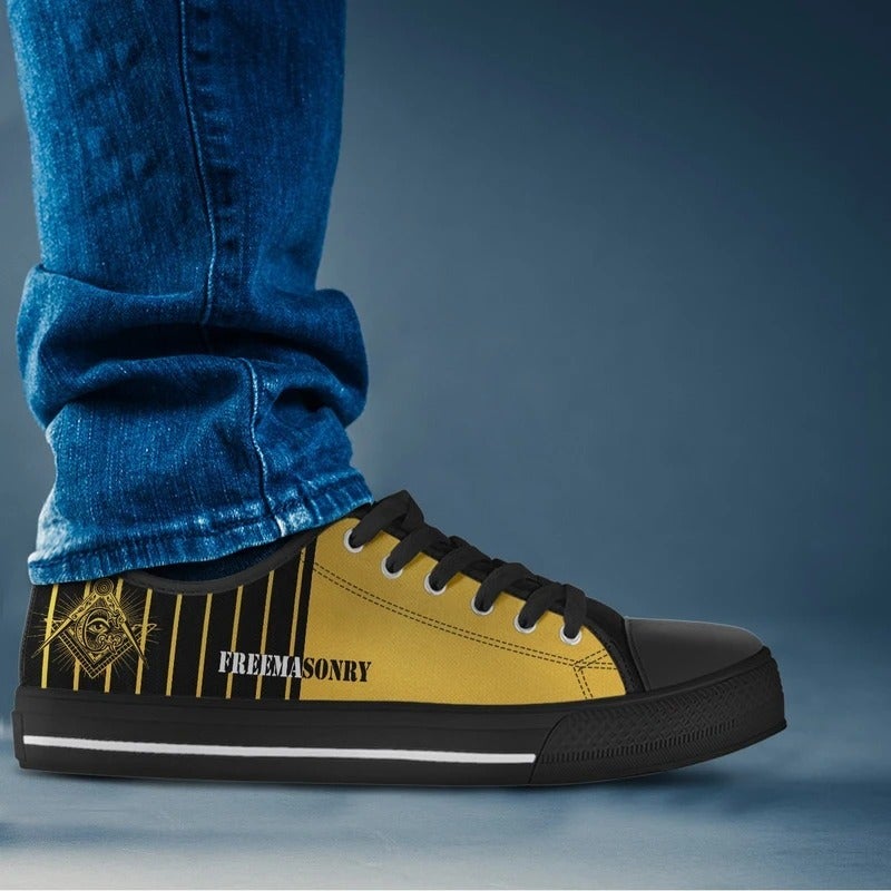 Low-top Freemasonry sneakers in yellow with black sole; worn with blue jeans