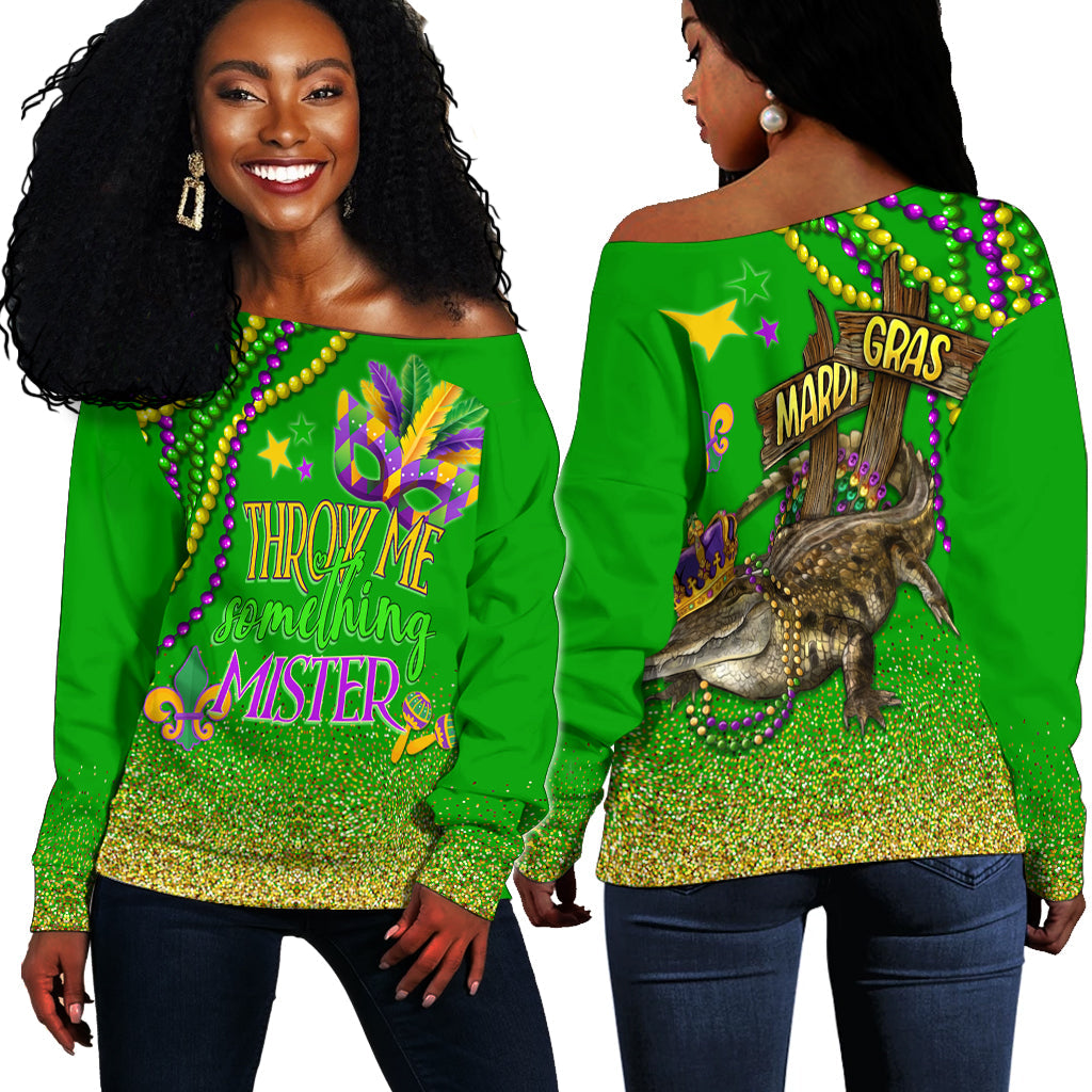 Green off-shoulder sweater with long sleeves, glitter hem and Mardi Gras graphic print.
