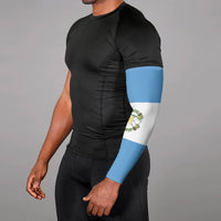 Worn Guatemala flag arm sleeve on forearm, blue-and-white with small emblem panel