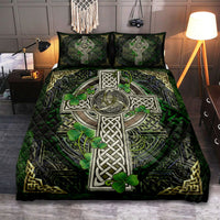 Quilt bed set featuring large Celtic cross with shamrock clover, dark green quilt and pillows
