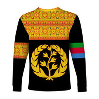 Black long sleeve shirt with large gold tree emblem; patterned upper back and striped sleeves