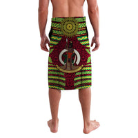 Red lavalava sarong with circular sunburst emblem, central figure, and green yellow trim