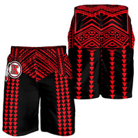 Two pairs of black swim shorts with red tribal print and crest logo
