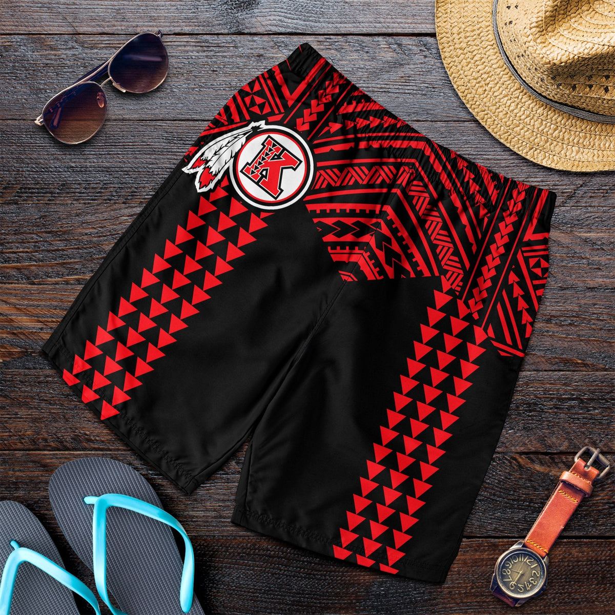 Men’s black swim shorts with red tribal pattern and crest logo at front