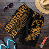 Men's black swim shorts with gold tribal warrior print and elastic waistband