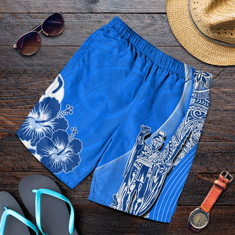 Men's blue swim shorts with white floral and king graphic, elastic waistband.