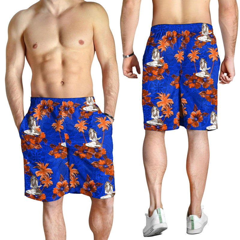 Men's blue swim shorts with orange floral print and hula dancer figures on model