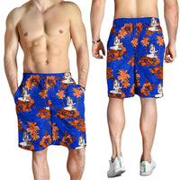 Men's blue swim shorts with orange floral print and hula dancer figures on model