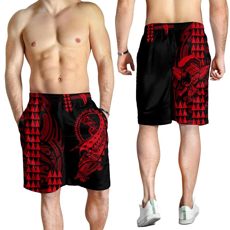 Men's black swim shorts with red tribal print, worn by male model, above-knee