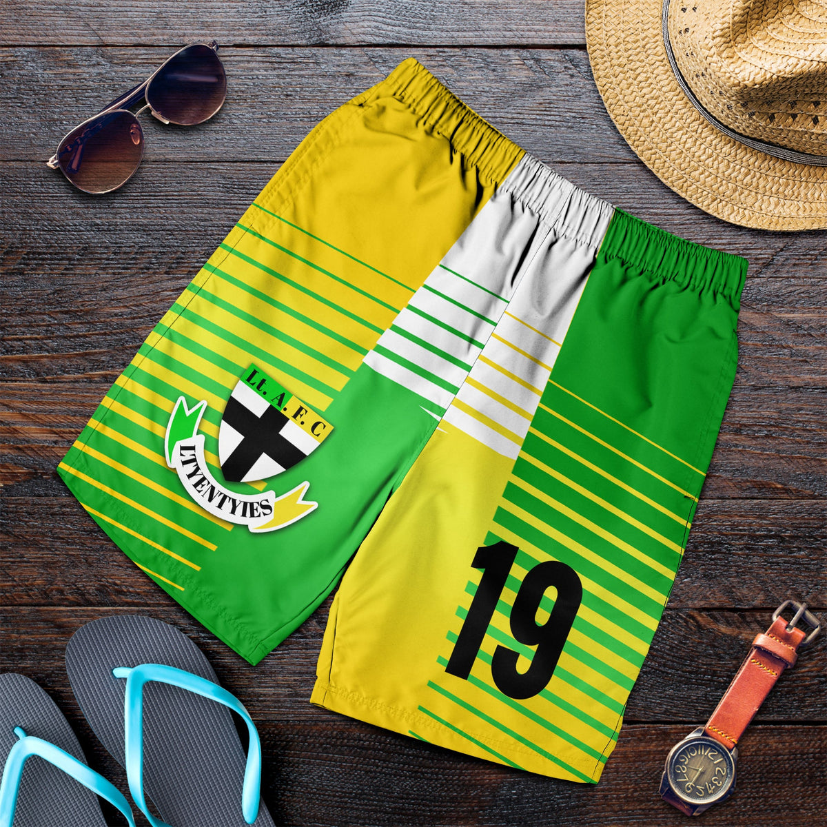 Folded green and yellow striped men’s shorts with club logo and large number 19