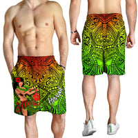 Men's tropical swim shorts on model, orange and green tribal print with hula girl and Aloha