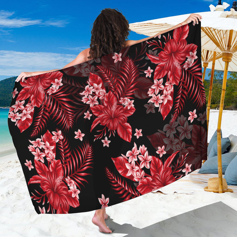 Red floral tropical sarong with pink blossoms on dark base, draped wide wrap.
