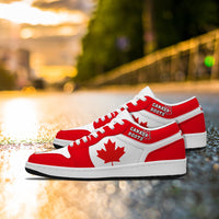 Red and white Canada Roots low-top sneakers with maple leaf emblem, white laces