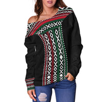Black off-shoulder sweater, geometric panel design with green, red, and white