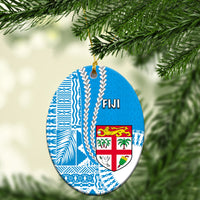 Fiji oval ceramic Christmas ornament with blue pattern and crest, hanging on gold cord