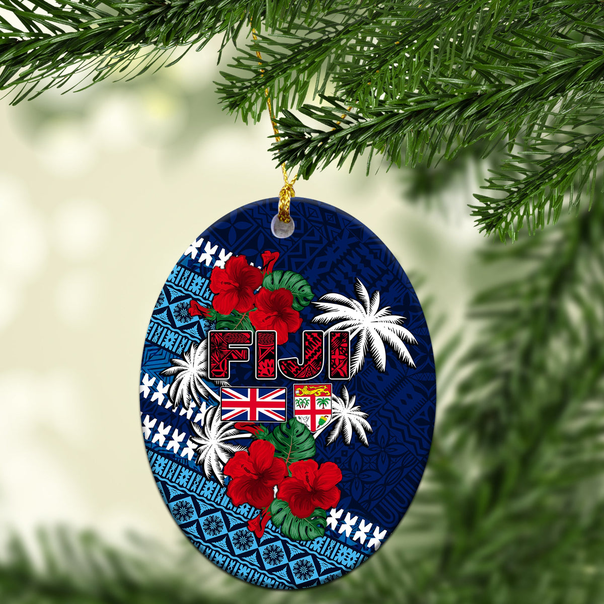 Blue oval ceramic Christmas ornament with Fiji lettering, flags, hibiscus and palm print.