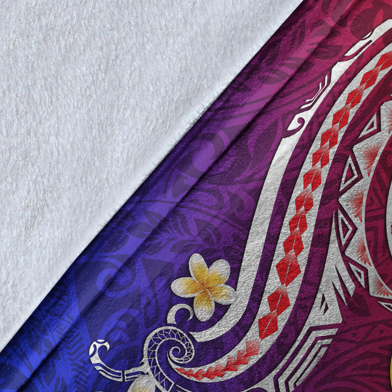 Close-up of Hawaiian blanket corner: purple and blue gradient fabric with white swirl and flower