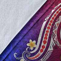 Close-up of Hawaiian blanket corner: purple and blue gradient fabric with white swirl and flower