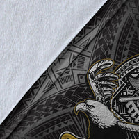 Close-up of black Samoa blanket fabric with white piping, eagle graphic edge, and geometric pattern.