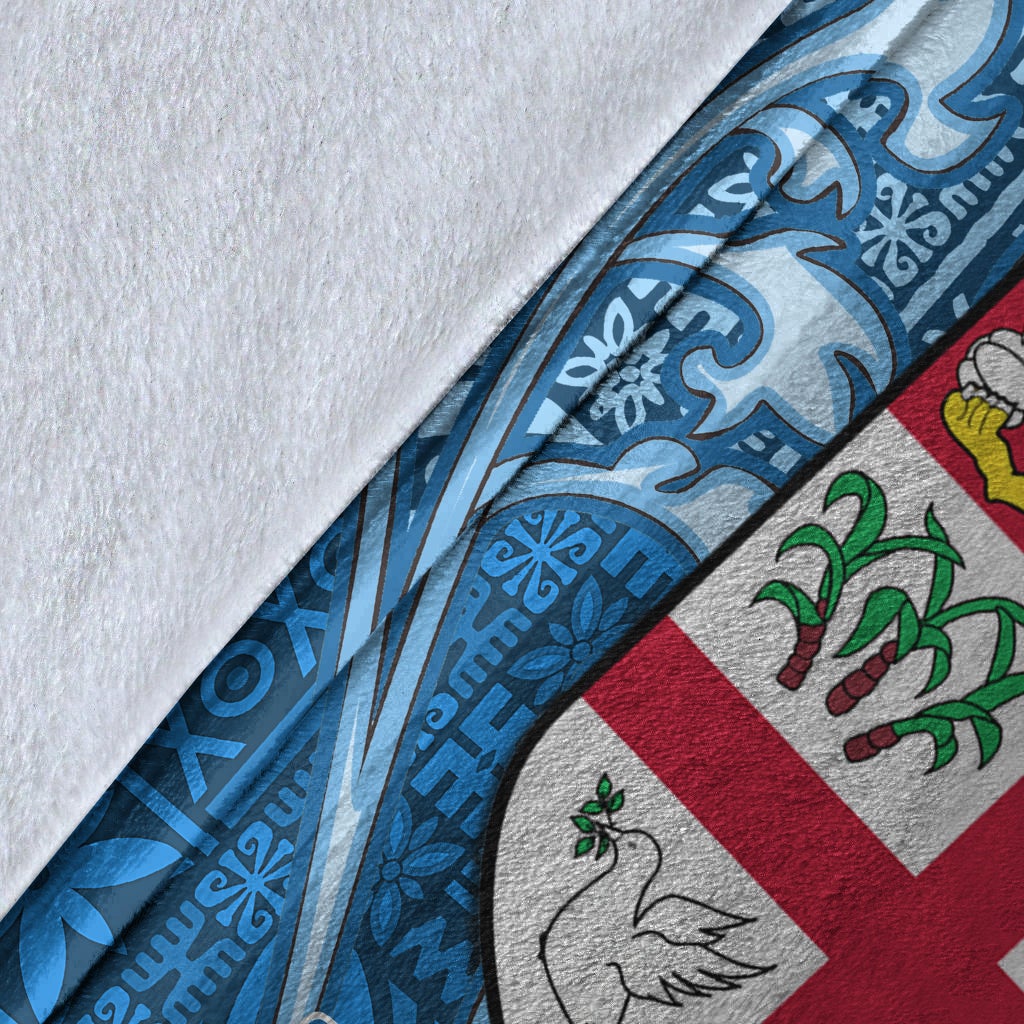 Close-up of blue tapa blanket fabric with Fiji flag cross and crest graphics