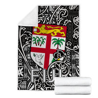 Black and white tapa-pattern blanket with Fiji flag cross, folded with white backing